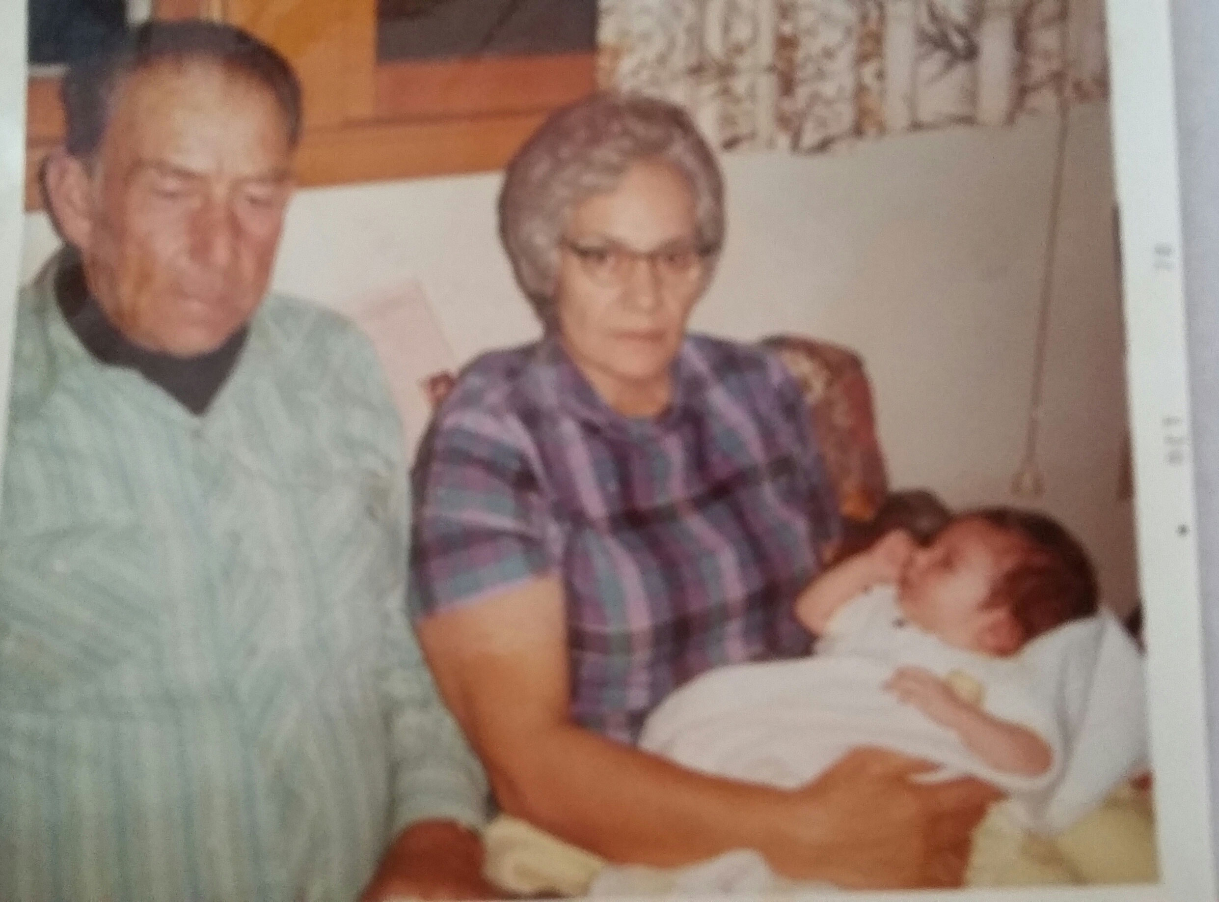 This is a picture of my Uncle Bud and Aunt Jo showing traditional Lakota generosity as they hold my firstborn son Clint.